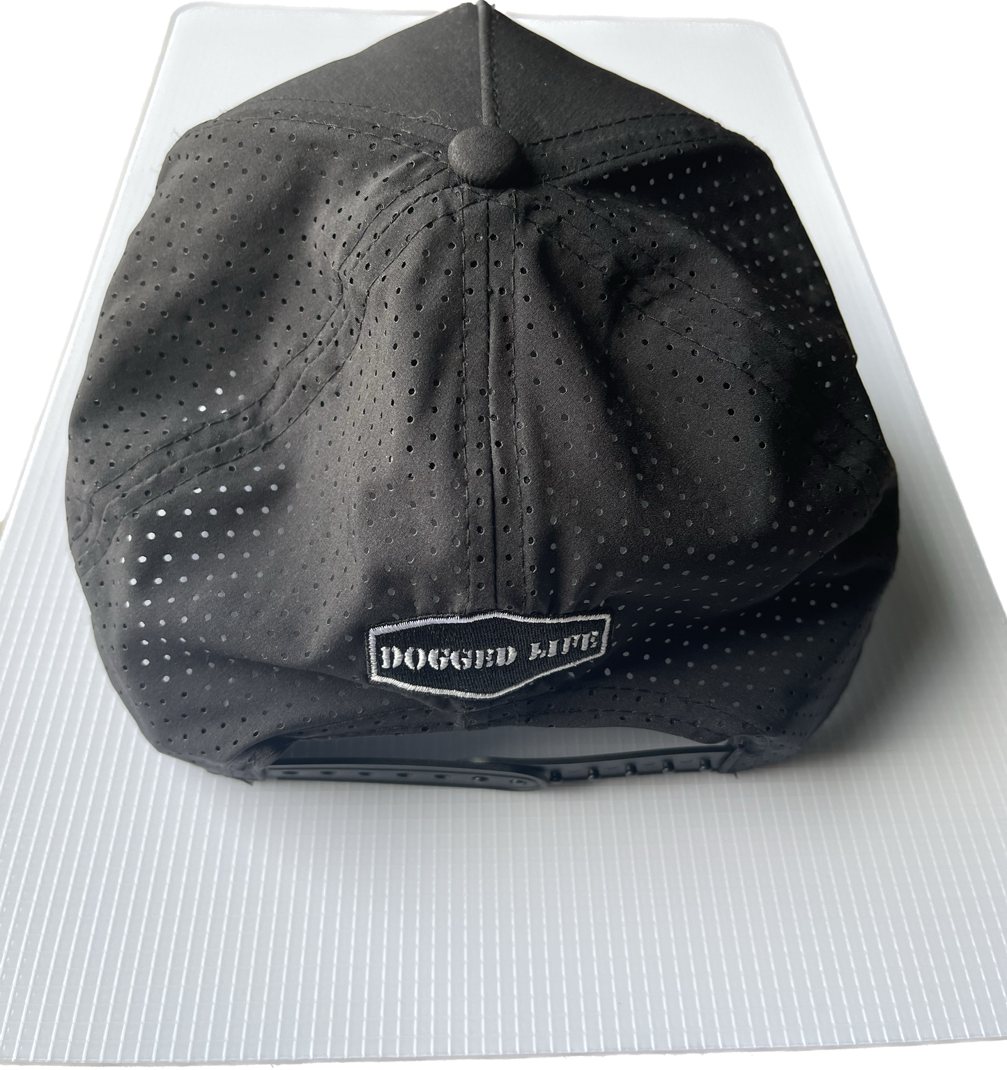 Dogged Life black perforated Tritech cap with Bongo Patch, moisture-wicking, lightweight, and SPF 30 protection.